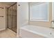 Bright bathroom with a soaking tub, glass shower, and neutral tile flooring at 700 Ridgeway Ct, Canton, GA 30114