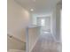 Upstairs hallway with gray carpet and a sunlit window at the end at 110 Alpine Rd, Fairburn, GA 30213