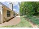 An angle view of the backyard showcasing the concrete patio, lawn, trees, and landscaping at 2175 Charleston Oak Cir, Lawrenceville, GA 30043