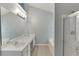 Bright bathroom boasts double sink vanity, large mirror, modern lighting, soaking tub, and a glass-enclosed shower at 2175 Charleston Oak Cir, Lawrenceville, GA 30043