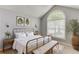 Charming bedroom featuring vaulted ceiling, arched window, neutral colors, and stylish decor at 2175 Charleston Oak Cir, Lawrenceville, GA 30043