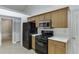 A compact kitchen features wood cabinets, a black refrigerator and gas range, plus light countertops at 2175 Charleston Oak Cir, Lawrenceville, GA 30043