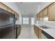 A galley kitchen with stainless steel appliances, wood cabinets, and a view into the dining area at 2175 Charleston Oak Cir, Lawrenceville, GA 30043