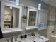 Bright bathroom featuring double sinks, quartz countertop, a large mirror, and a tiled walk-in shower at 2298 Hillbriar Dr, Buford, GA 30518