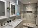 Modern bathroom featuring double sinks, quartz countertop, a large mirror, and a tiled walk-in shower at 2298 Hillbriar Dr, Buford, GA 30518