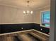 Dining room featuring an elegant chandelier, wainscoting, and plenty of natural light from the large window at 2298 Hillbriar Dr, Buford, GA 30518