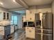 Modern kitchen with stainless steel appliances, white cabinets, tile backsplash, and an adjacent laundry area at 2298 Hillbriar Dr, Buford, GA 30518