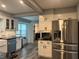 Modern kitchen with stainless steel appliances, white cabinets, tile backsplash, and an adjacent laundry area at 2298 Hillbriar Dr, Buford, GA 30518