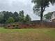 Well-maintained yard featuring a beautiful flower bed under a mature tree, offering shade and visual appeal at 2298 Hillbriar Dr, Buford, GA 30518
