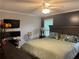 Comfortable main bedroom with dark accent wall, ceiling fan, and a large bed with floral pillows at 2298 Hillbriar Dr, Buford, GA 30518