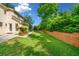 Lush backyard with green lawn, trees, and brick retaining wall at 720 Belgrave Ln, Tucker, GA 30084