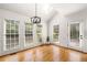 Bright breakfast nook featuring hardwood floors, a modern chandelier, and large windows overlooking the greenery outside at 720 Belgrave Ln, Tucker, GA 30084