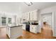 Open concept kitchen with island, black countertops and views to a living area, providing seamless flow and functionality at 720 Belgrave Ln, Tucker, GA 30084