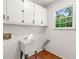 Functional laundry room featuring white cabinets, a utility sink, and a window providing natural light at 720 Belgrave Ln, Tucker, GA 30084