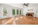 Bright living room showcasing hardwood floors, fireplace with brick surround and large windows offering an outdoor view at 720 Belgrave Ln, Tucker, GA 30084