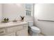 Cozy powder room showcasing a classic vanity, toilet, and a window allowing for natural light at 720 Belgrave Ln, Tucker, GA 30084
