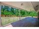 Covered back porch with brick wall, wood-look tile flooring and metal railing at 2133 Bird Ln, Snellville, GA 30078