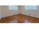 Bright bedroom showcasing lustrous hardwood flooring and natural light streaming through two windows at 2133 Bird Ln, Snellville, GA 30078