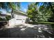 View of the home's back with an attached garage and an ample-sized paved parking area at 239 Clear Brook Trl, Douglasville, GA 30134