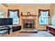 Cozy fireplace with stone surround flanked by large windows at 239 Clear Brook Trl, Douglasville, GA 30134