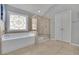 Relaxing bathroom featuring a soaking tub, a glass-enclosed shower, and a decorative stained glass window at 4100 Secret Shoals Way, Buford, GA 30518