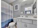 Bathroom featuring gray walls and a blue shower curtain, also featuring a view to the bedroom at 4100 Secret Shoals Way, Buford, GA 30518