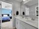 Well-lit bathroom featuring double sinks, gray walls, and a view into the bedroom at 4100 Secret Shoals Way, Buford, GA 30518