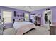 Bedroom features purple walls, carpeted floors, a ceiling fan, and a double bed under the window at 4100 Secret Shoals Way, Buford, GA 30518