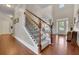 Bright foyer with hardwood floors, staircase with wrought iron railings, and a view of the front entrance at 4100 Secret Shoals Way, Buford, GA 30518