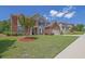 A beautiful two-story home boasts a lush green lawn and landscaped garden with a brick and stone facade at 4100 Secret Shoals Way, Buford, GA 30518