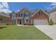 Charming two-story home with brick and stone accents, manicured lawn and a two car garage at 4100 Secret Shoals Way, Buford, GA 30518