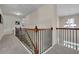 Upstairs hallway with carpet, wood railing, and natural light from windows at 4100 Secret Shoals Way, Buford, GA 30518