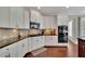 Bright kitchen features white cabinets, modern appliances, granite counters, and hardwood floors at 4100 Secret Shoals Way, Buford, GA 30518