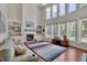 Bright living room featuring a stone fireplace, hardwood floors, and large windows with backyard views at 4100 Secret Shoals Way, Buford, GA 30518