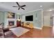 Cozy living room with a fireplace, hardwood floors, and a ceiling fan at 4100 Secret Shoals Way, Buford, GA 30518
