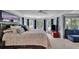 Large main bedroom with a seating area, a ceiling fan, and several large sunny windows at 4100 Secret Shoals Way, Buford, GA 30518