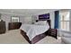 Bright main bedroom with a king-sized bed, a ceiling fan, and ample natural light from the windows at 4100 Secret Shoals Way, Buford, GA 30518