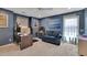Room featuring blue walls, carpeted floors, a ceiling fan, a gray couch and a desk space at 4100 Secret Shoals Way, Buford, GA 30518
