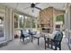 Cozy screened-in porch with a stone fireplace and comfortable seating, ideal for relaxing outdoors at 4100 Secret Shoals Way, Buford, GA 30518