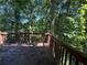 Wooden deck with a railing overlooks a verdant wooded area at 4649 Camelot Dr, Douglasville, GA 30135