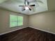 Bedroom with tray ceilings, hardwood floors, natural light from a large window, and neutral colored walls at 4649 Camelot Dr, Douglasville, GA 30135