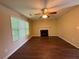Living room featuring hardwood floors, a ceiling fan, a fireplace, and natural light from a large window at 4649 Camelot Dr, Douglasville, GA 30135