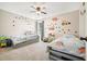 Bedroom featuring two twin beds, dinosaur accents, and a ceiling fan at 537 Autumn Ridge Dr, Canton, GA 30115