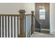Staircase with grey patterned wall, modern light fixture, and wooden railing with black spindles at 1846 Butterfly Way, Marietta, GA 30066