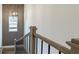 Staircase with grey patterned wall, modern light fixture, and wooden railing with black spindles at 1846 Butterfly Way, Marietta, GA 30066