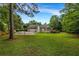 Picturesque backyard showcases a spacious lawn, mature trees, and a detached two-car garage at 3018 Saint Andrews Ct, Jonesboro, GA 30236