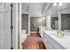 Bathroom features double sinks with marble countertops, patterned wallpaper and red tile flooring at 3018 Saint Andrews Ct, Jonesboro, GA 30236