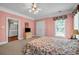 Bedroom features neutral carpet, pink walls, large windows, and adjacent bathroom at 3018 Saint Andrews Ct, Jonesboro, GA 30236