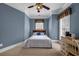 Blue bedroom features neutral carpet, window with blinds, ceiling fan and desk with chair at 3018 Saint Andrews Ct, Jonesboro, GA 30236
