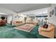 Spacious living room with green carpet, multiple sofas, and adjacent dining area at 3018 Saint Andrews Ct, Jonesboro, GA 30236